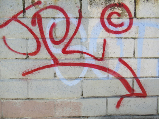 a red and white graffiti on a white wall