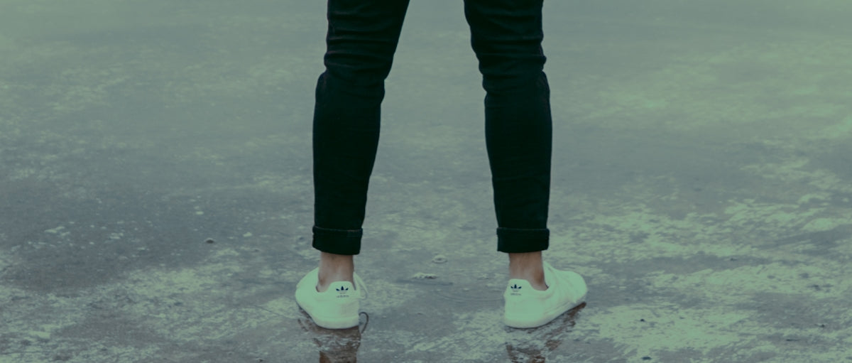 man wearing white sneakers and black pants