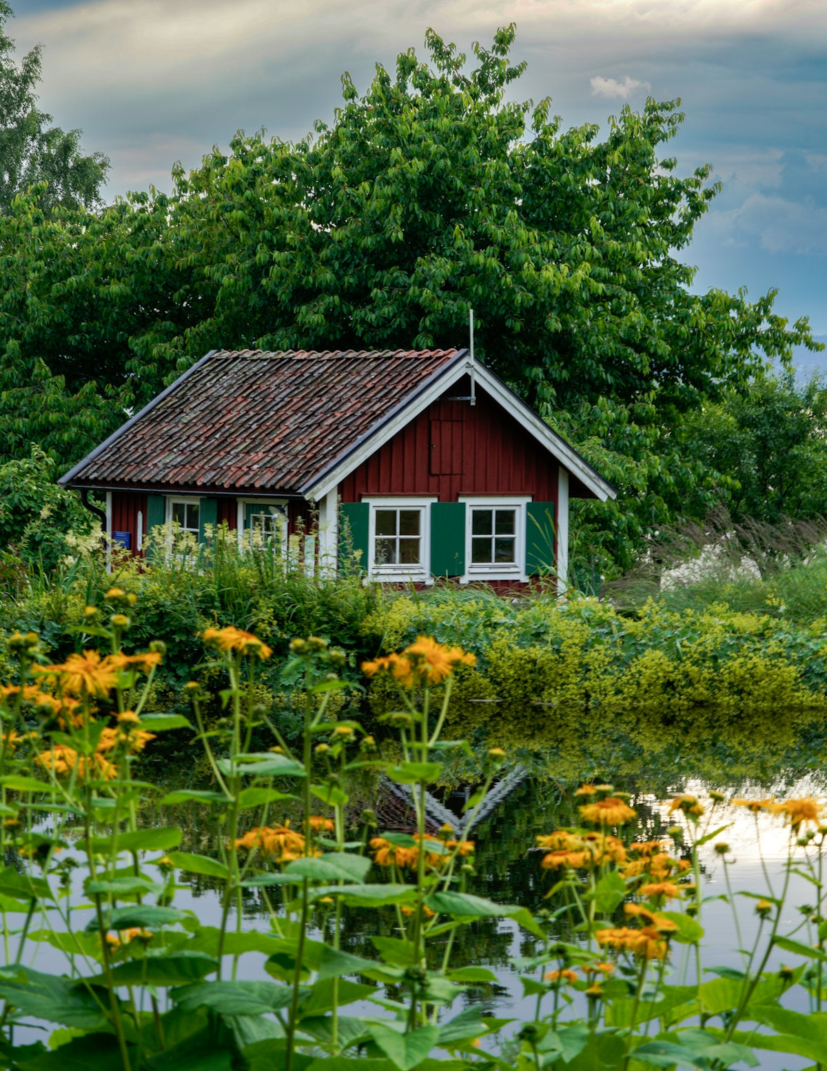 A red house sitting next to a body of water
