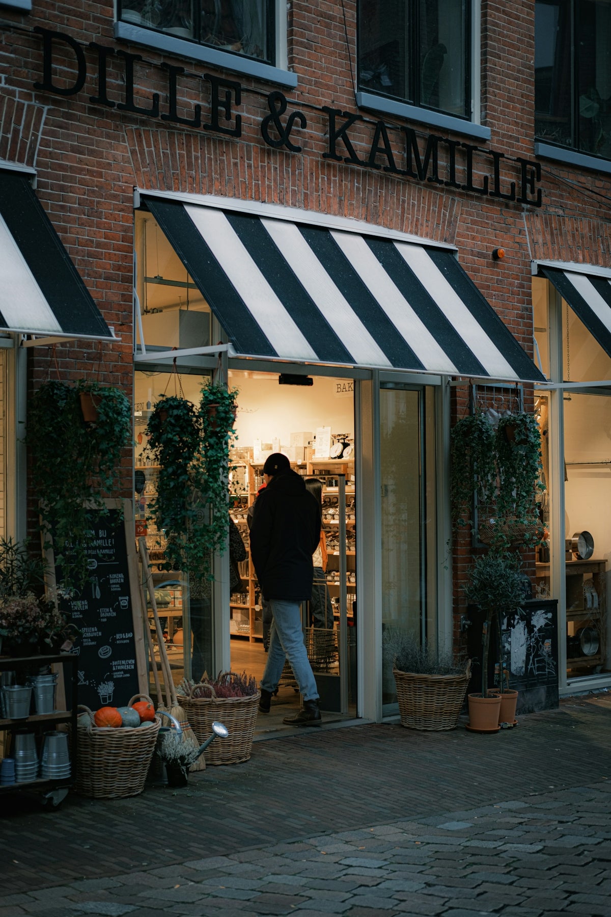 A person walking out of a store with a black and white awning