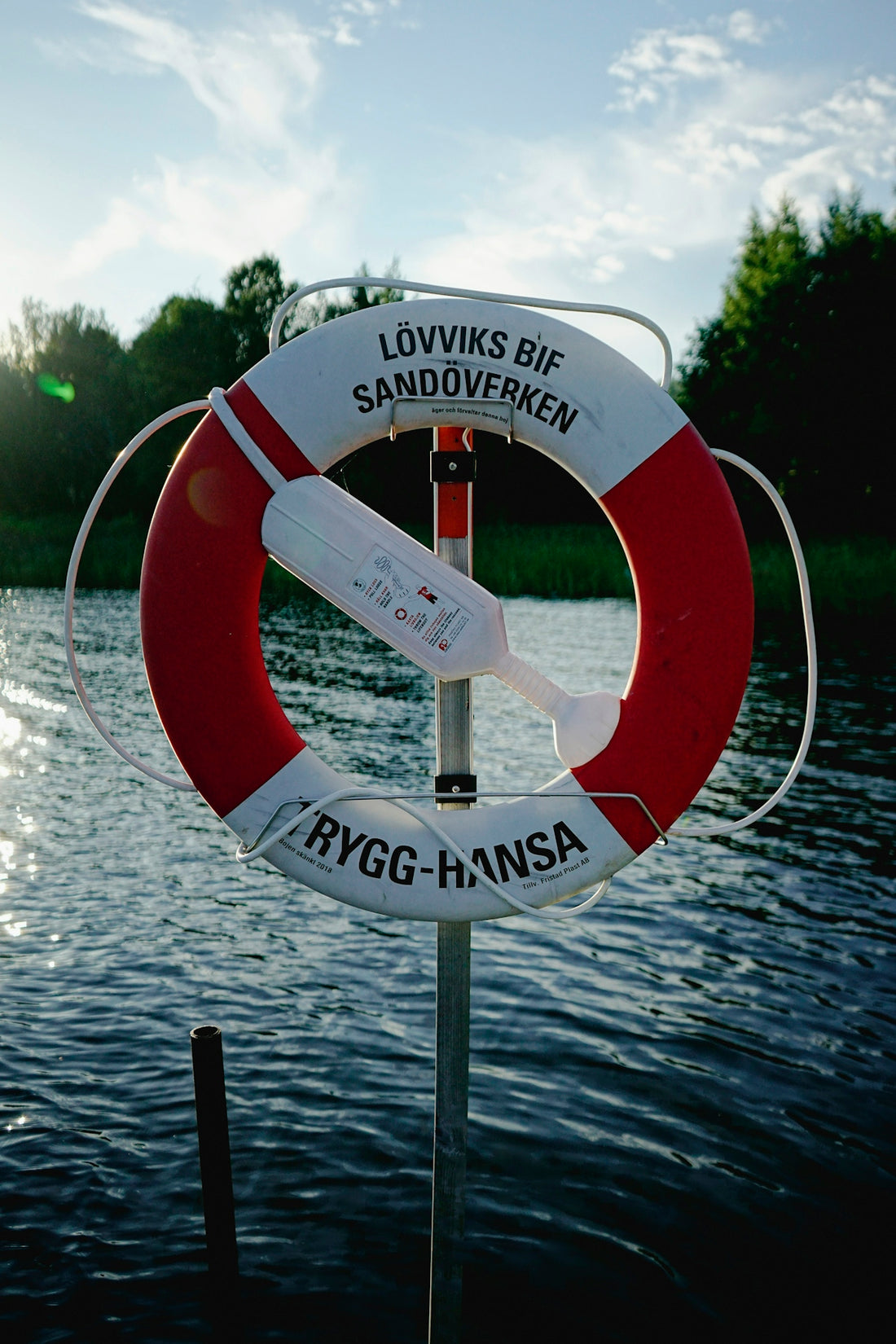 A red and white life preserver sitting on top of a body of water