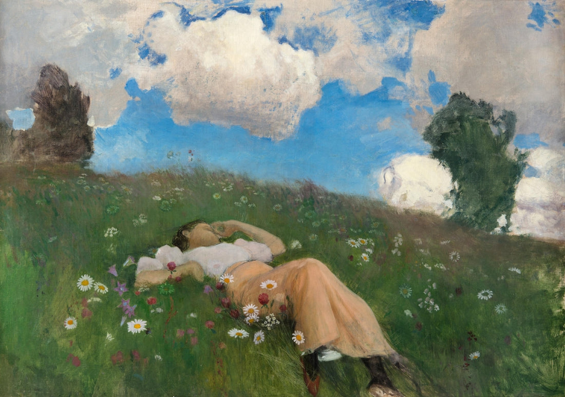 Woman lying in a field of wildflowers under clouds