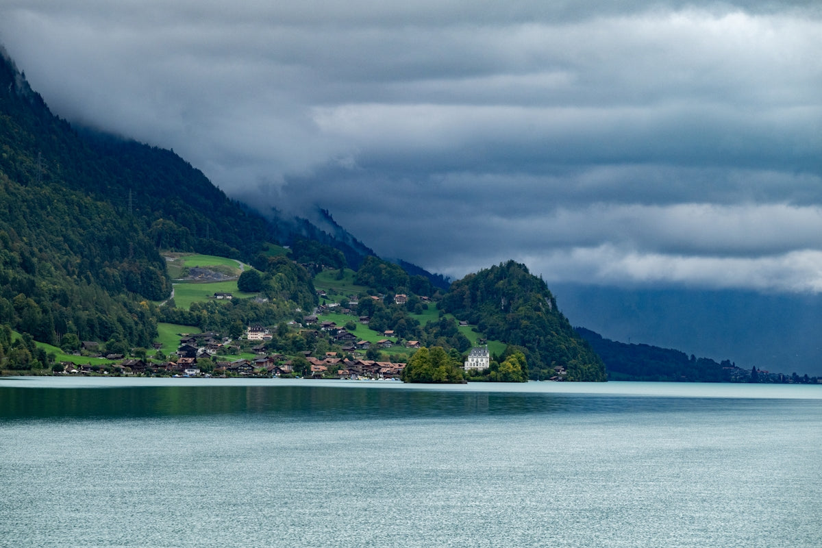 A serene lake with a village nestled in green mountains.