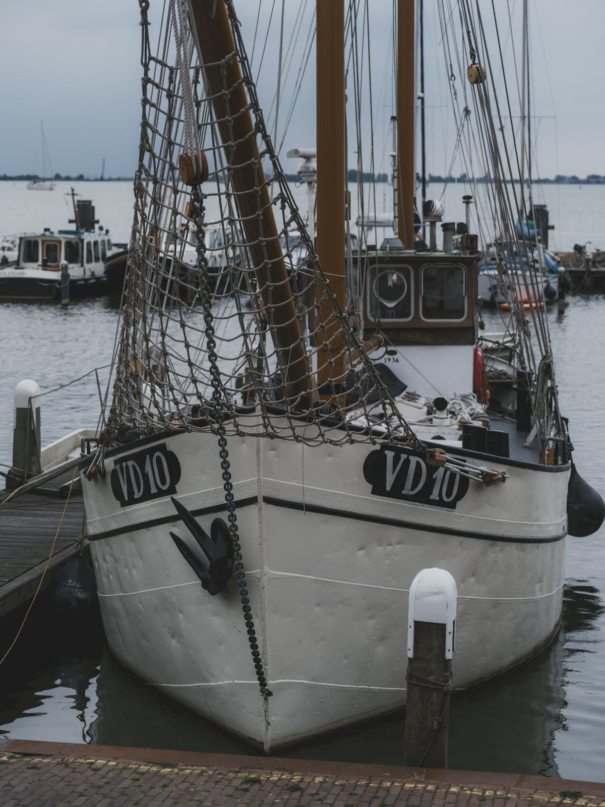 A white fishing boat docked at a pier